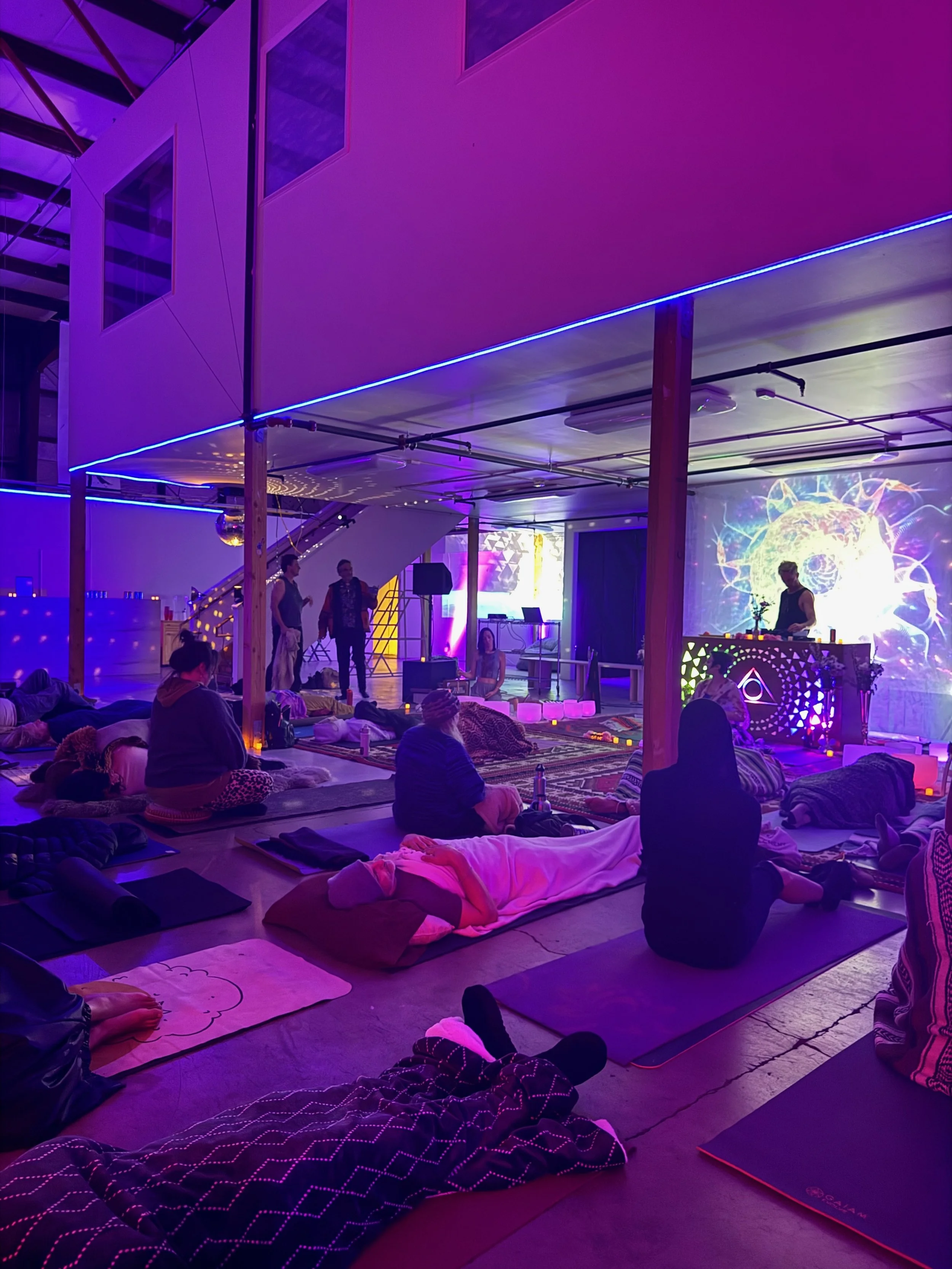 People gathered on mats inside a colorful, illuminated space at Laguna Lab.